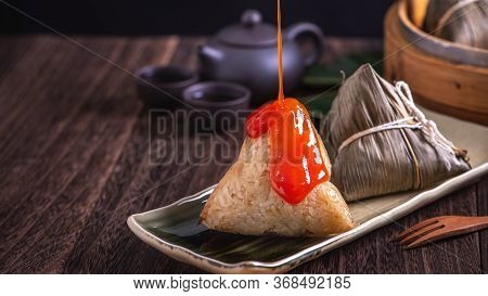 Rice Dumpling, Zongzi - Bunch Of Chinese Traditional Cooked Food On Wooden Table Over Black Backgrou