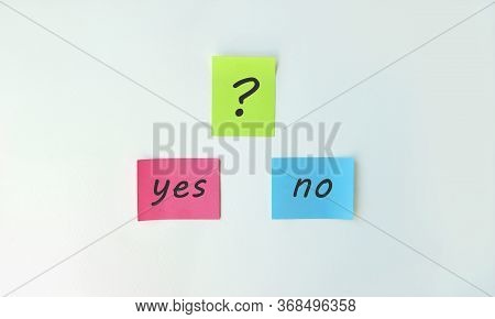 Photo Two Stickers With The Phrase Yes Or No And With A Sticker With A Question Mark On A White Back