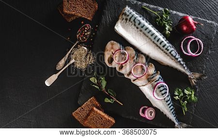 Marinated Mackerel Or Herring Fish With Spices On Slate Board With Greens, Onion. Mediterranean Food