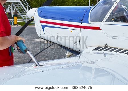 Close Up Of An Aircraft Worker Fueling Low-wing Propeller Driven Airplane