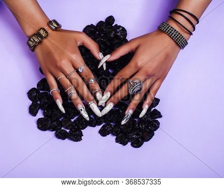 Woman Hands With Long Nails Manicure Holding Dry Fruits In Shape Of Heart On Purple Background