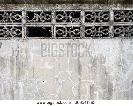 The Concrete Wall Is Dirty And Stained Gray Color. With A Broken Cement Ventilator In The Top. With 