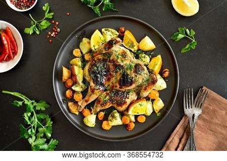 Spatchcocked Grilled Chicken With Vegetables On Plate On A Over Black Stone Background. Top View, Fl