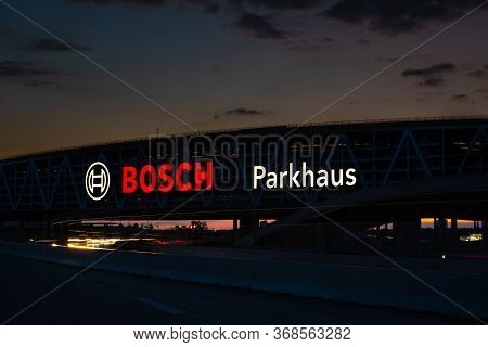 Huge Bosch Letters At The Stuttgart Airport Parking Garage With Long Exposure Of Highway A8 At Dusk.