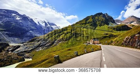 Panoramic view at Pasterze Glacier Grossglockner among austrian Alps mountains summits blue sky clouds.