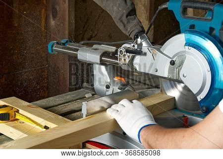 Closeup Of Professional Cabinet Makers Working With Electric Circular Saw At Woodworking Workshop. S