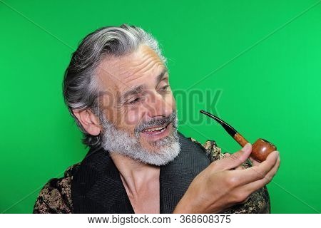 Happy Mature Caucasian Man Smoking A Pipe