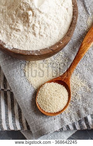 Raw Fonio Flour And Seeds With A Spoon On Grey Napkins Close Up. Alternative Flour