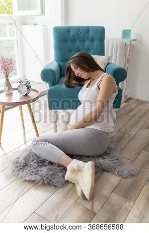 High Angle View Of A Beautiful Young Nine Months Pregnant Woman Relaxing At Home, Expecting Her Baby