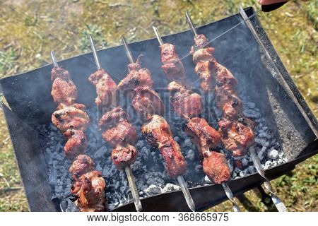Cooking Meat On The Grill. Fried Food Over Charcoal. Barbecue Weekend. Meat Languor At Low Temperatu