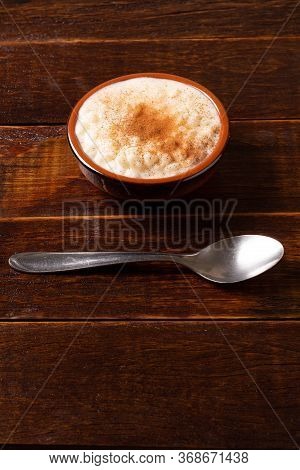 White Corn Cooked With Milk Known As Canjica, Canjicão Or Mungunza, In A Rustic Bowl On Wooden Table