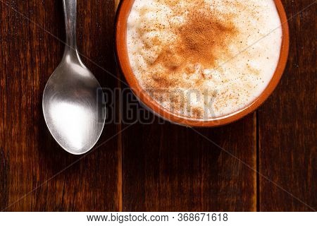 White Corn Cooked With Milk Known As Canjica, Canjicão Or Mungunza, In A Rustic Bowl On Wooden Table