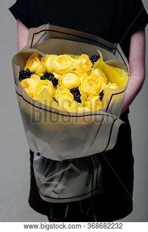 Bouquet Of Flowers In Transparent Package In The Hands Of A Woman Florist. Rosa Spray Catalina, Rham