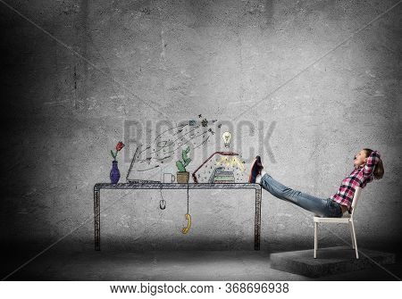 Young Happy Woman Relaxing In Room. Creative Freelance Designer Sitting On Chair And Putting Feets O