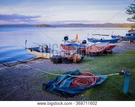 Row Of Typical Fishermen Boats Docked On Marta Beach, A Little Medieval Village On Bolsena Lakeshore