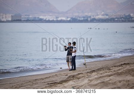 Muscat, Oman. May 29, 2020. On The First Evening Of Lockdown Being Lifted, Two Men Wearing Face Mask