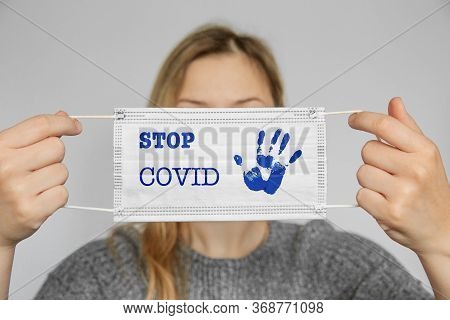 Girl Holds A Medical Mask In The Face.stop Covid.