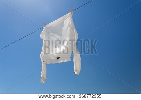 White Shirt Hanging To Dry On Clothes Line