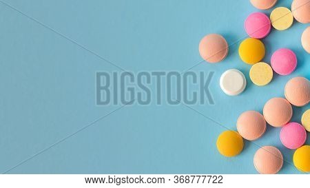 Pile Of Colorful Pills On A Blue Background, Conceptual Image