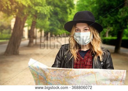 Young Girl With A City Map On The Street On A Trip. Looking At The Camera