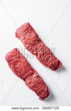 Raw Set Of Denver Steak On A White Stone Background Vertical