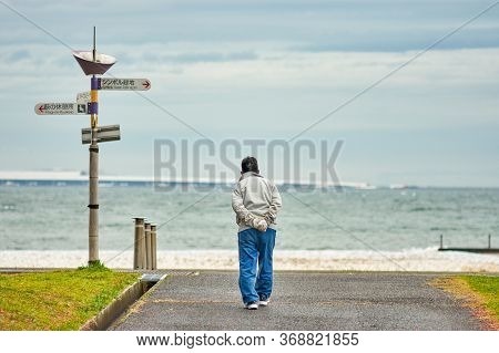 Osaka / Japan - March 21, 2018: Old Japanese Man Walking Towards The Sea