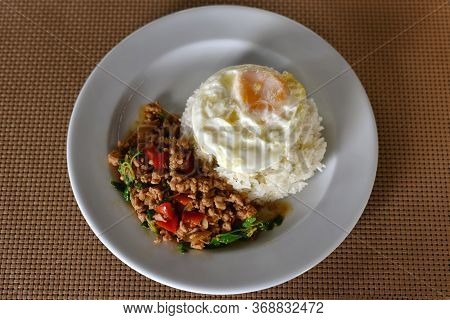 Thai Food, Rice Topped Stir-fried Chicken And Basil With Fried Egg On White Plate. Is Popular Menu O