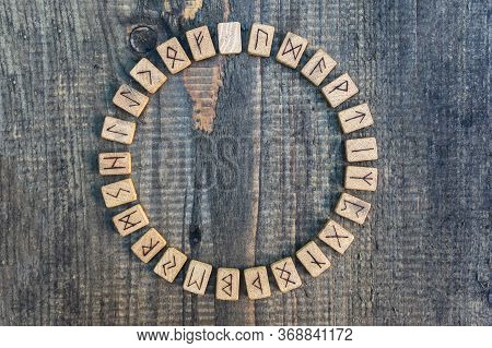 Scandinavian Wooden Runes On An Old Wooden Table. Elder Futhark.