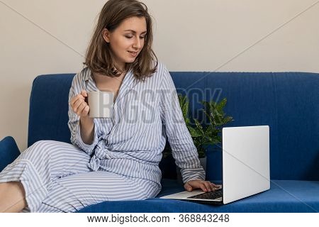 Woman Working On Laptop At Home Office While Drinling Coffee. Web Conection