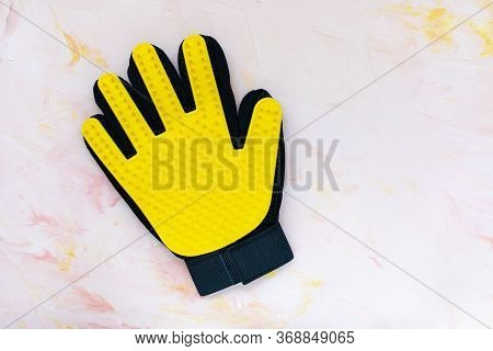 Yellow Silicone Glove For Cats And Dogs Grooming On Pink Background, Copy Space. Pets Care, Hand Mas