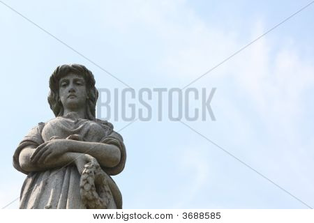 Estátua de pedra da mulher contra o céu azul