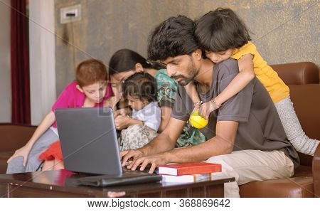 Children Or Kid Playing By Riding On Father Back And Disturbing While Father Busy In Working On Lapt
