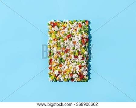 Frozen Vegetables Assorted On Blue Background. Assorted Frozen Vegetables Food With Ice, Top View Or
