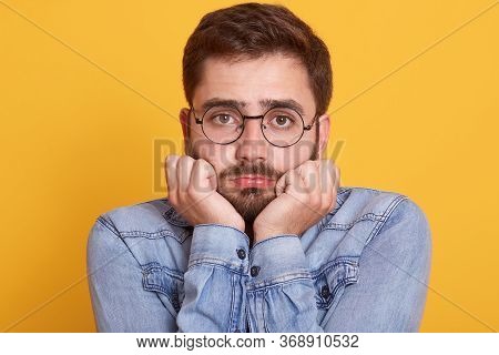 Close Up Portrait Of Sad Upset Handsome Guy Having Beard, Looking Directly At Camera, Putting Hands 