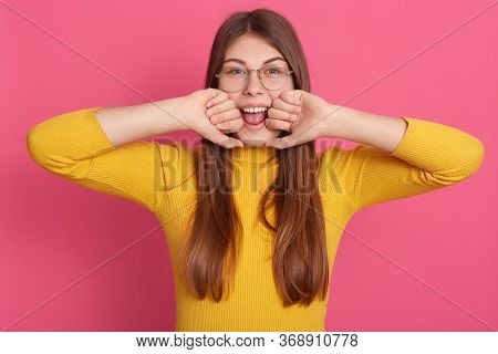 Horizontal Shot Of Magnetic Attractive Adorable Young Girl Opening Mouth Widely, Looking Directly At