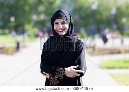 Portrait Of A Muslim Woman In Black Clothes. Islamic Woman In National Dress Black Clothes Close-up