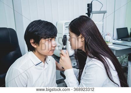 Consultation With An Ophthalmologist. Young Asian Man And Woman Doctor