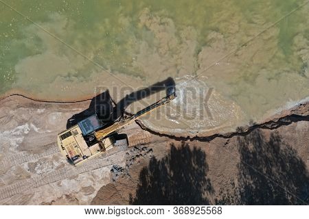 Environmental conservation issue. Machinery mining river, causing siltation and pollution 
