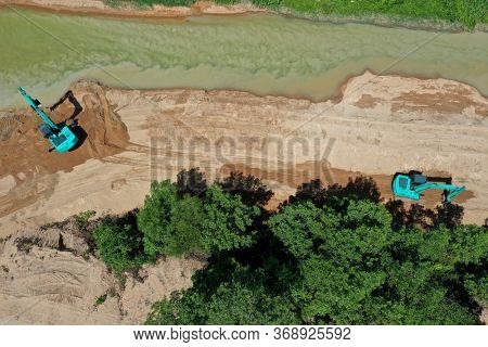 Environmental conservation issue. Machinery mining river, causing siltation and pollution 