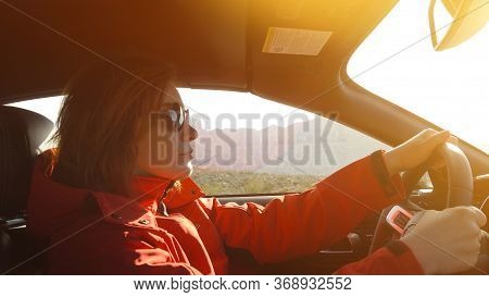 Woman Driving A Car. Young Woman Is Driving A Car On A Sunny Day. Confident Woman In Sunglasses Driv
