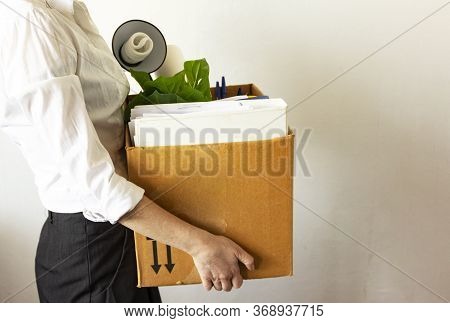 Lose Job Concept. Hand Holds Box Of Fired Worker. In A Box They Lay Documents, Folders, A Flower, St