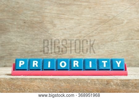Tile Letter On Red Rack In Word Priority On Wood Background