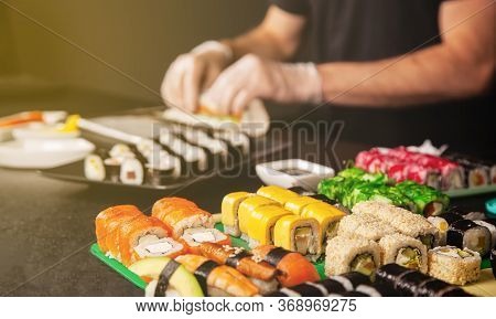 Cook Hands Making Japanese Sushi Roll. Japanese Chef At Work Preparing Delicious Sushi Roll With Eel