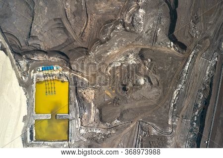 Top View On A Pool With Yellow Liquid Used In A Coal Mining In A Quarry. Heavy Industry Concept