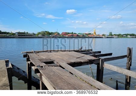 Old Wooden Bridge With Corrosive Steps And Riverside View At Koh-kret,nonthaburi,thailand And Blue S