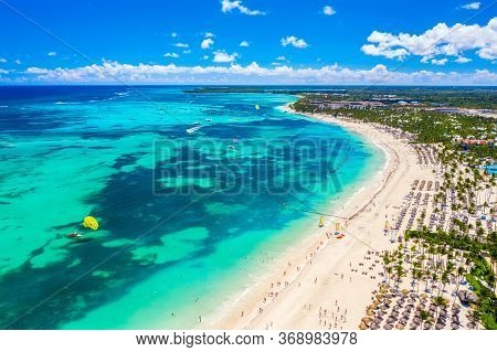Aerial Drone View Of Beautiful Atlantic Tropical Beach With Palms, Straw Umbrellas And Boats. Bavaro