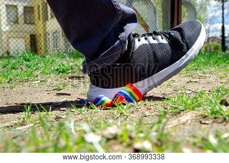 Trampling Of Lgbt Flag In Dirt By Radical Homophobe. Rainbow Lgbt Tape Is Stamped