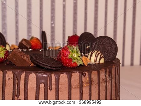 A Wonderful Sponge Cake Topped With Chocolate And Decorated With Cookies, Strawberries, Pieces Of Ch