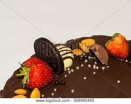 A Wonderful Sponge Cake Topped With Chocolate And Decorated With Cookies, Strawberries, Pieces Of Ch