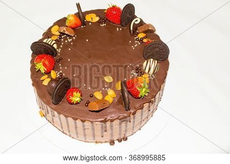 A Wonderful Sponge Cake Topped With Chocolate And Decorated With Cookies, Strawberries, Pieces Of Ch